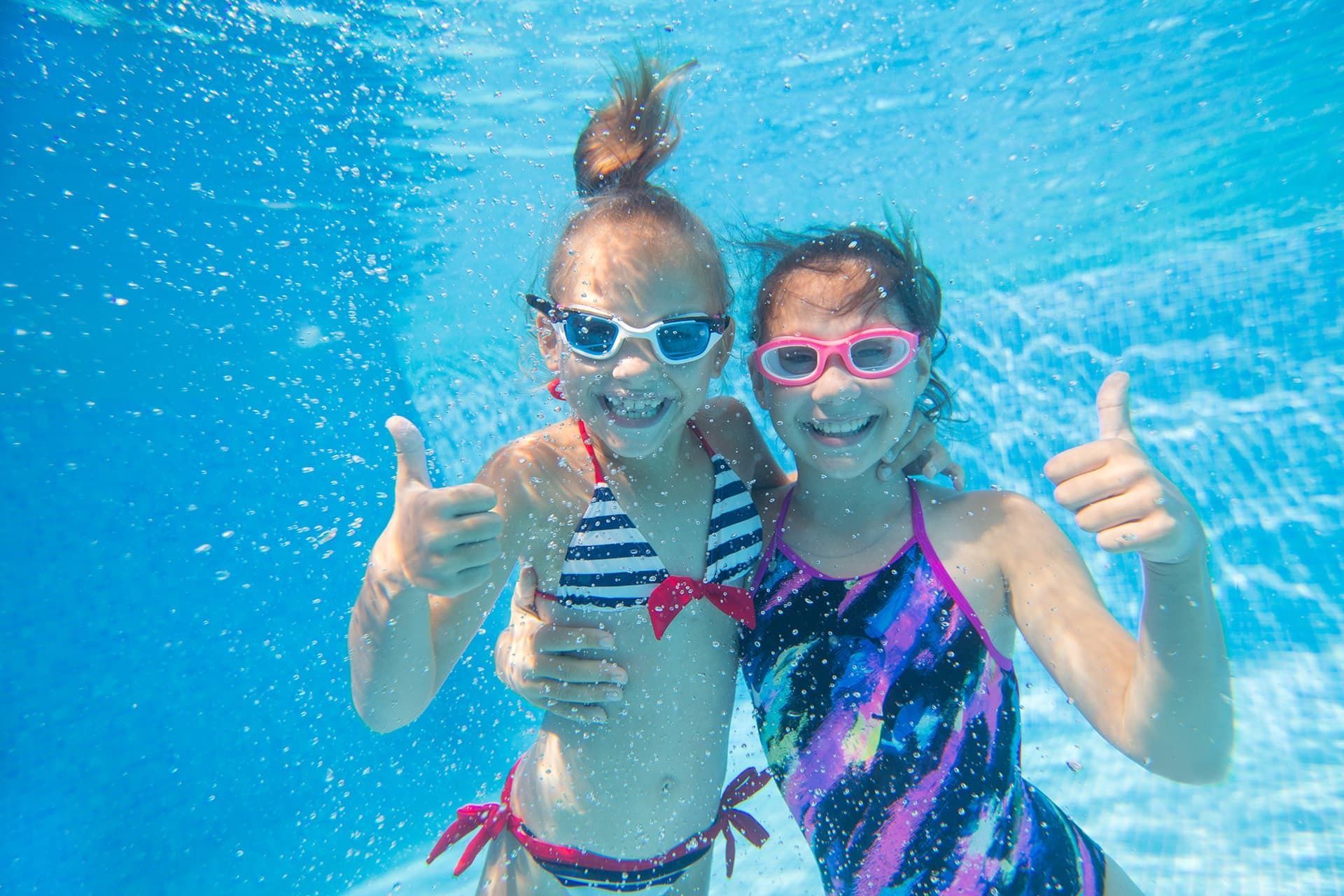 Zwei Mädchen fröhlich unter Wasser
